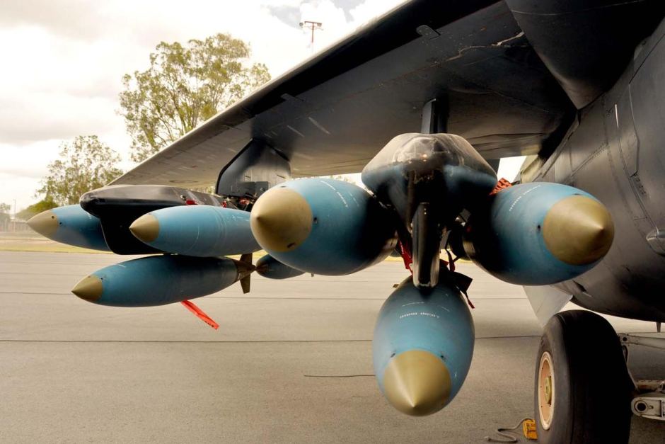 Bombs hang under the wing of an F-111