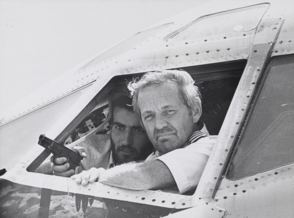 Captain John Testrake talks to newsmen from the cockpit of his Boeing 727 at Beirut airport, after TWA Flight 847 was hijacked during a routine flight from Cairo to San Diego with en route stops in Athens, Rome, Boston, and Los Angeles. On the morning of Friday, June 14, 1985