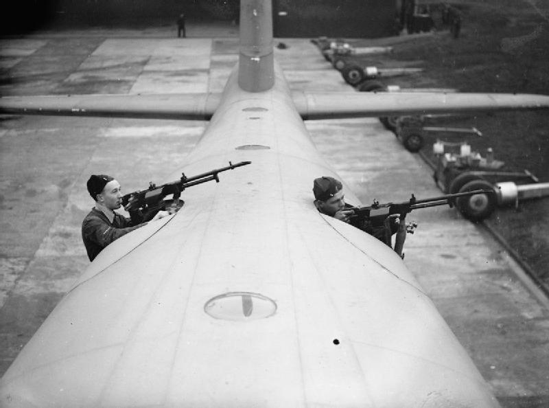 Two airmen demonstrate the dorsal .303in Vickers K guns of a Sunderland