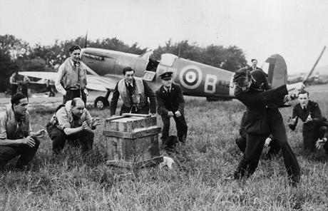 Pilots' Cricket...30th June 1941: A group of fighter pilots enjoying a game of cricket in their spare time between sweeps across the Channel to bomb Germany's frontline. Douglas Bader's Spitfire is parked in the field behind them.